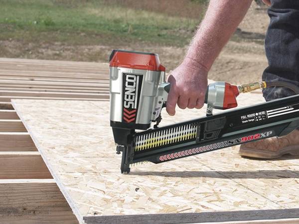 A man is securing the plywood with plastic collated framing nailer.