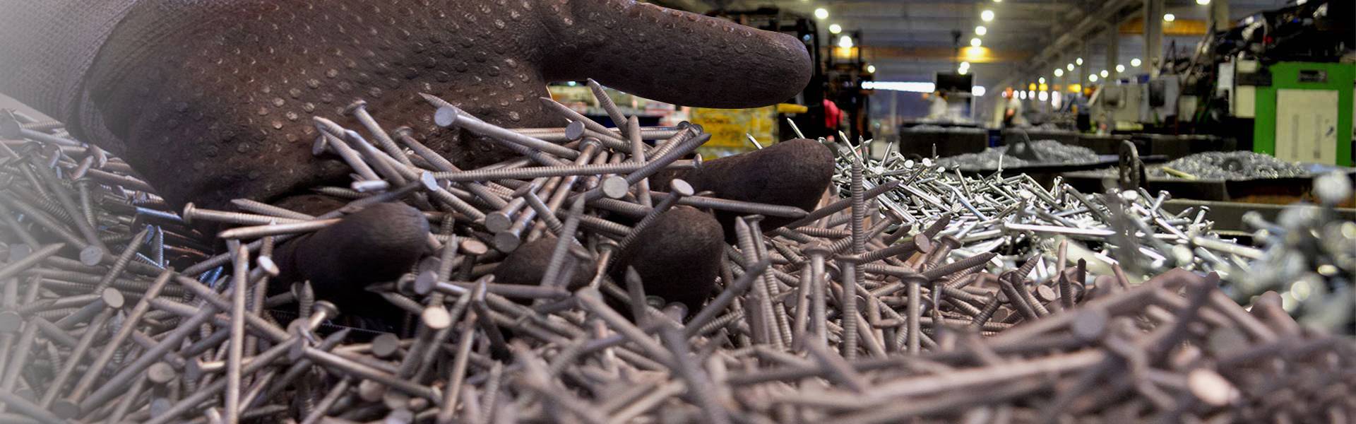 Une photo montre beaucoup de clous en fil d'acier et l'usine de production.