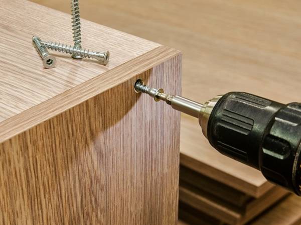 Installez le bureau avec des vis à bois par perceuse électrique.